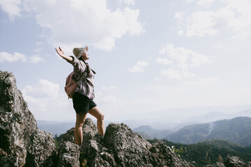 Woman hiker on top of mountain. Hiker with arms up on top of mountain successful young woman enjoying triumph. traveler exploring world. Hikers with backpacks relaxing. Sport and success concept.
