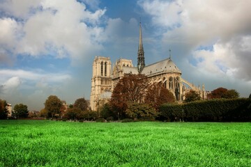 Naklejka premium Gothic cathedral spire is being shown in flat illustration with green lawn hedges autumn trees