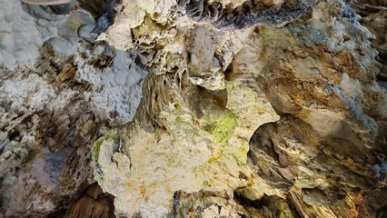 Inside Thien Cung Cave, Ha Long bay, Vietnam, showcasing dramatic stalactites and rugged limestone formations illuminated by soft lighting.