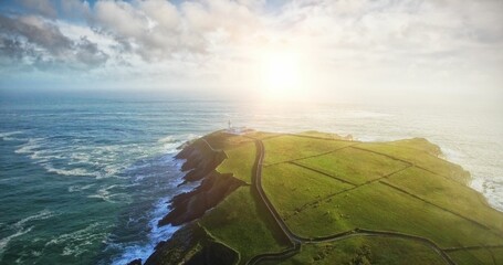 Grassy coastal peninsula in flat design is showing road between stone walls leading to lighthouse