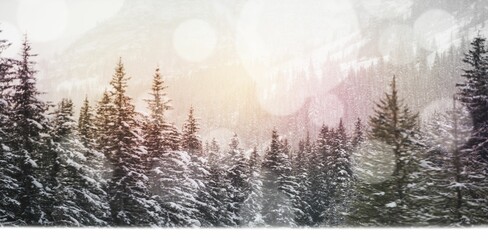 Defocused lights against snow covered trees and mountain