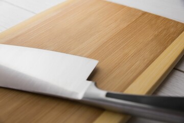 Large knife and chopping board on hardwood floor
