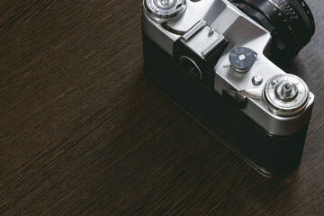 old mechanical camera. The controls such as the dials and shutter button are visible. The camera...