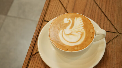 A cup of hot latte coffee on the table for breakfast
