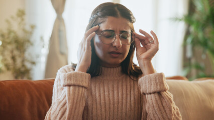 Woman, pain and headache of stress on sofa for financial crisis, overwhelmed or mental health....