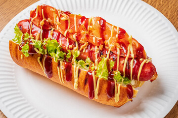 Delight in a gourmet hot dog adorned with vibrant toppings and sauces, perfect for any food lover