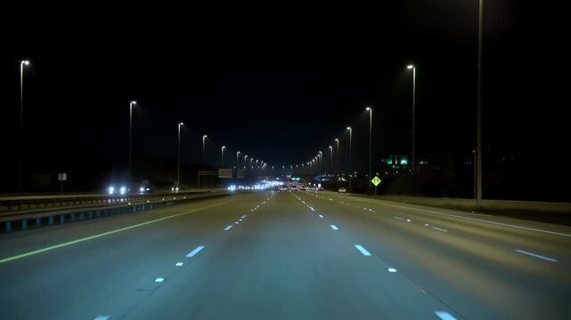 POV shot, driving on the empty illuminated highway in the traffic during the night. Cars, trucks on the road. Chicago, IL. 22 August 2024