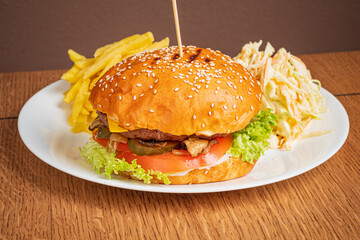 A delicious gourmet burger with lettuce, tomato, pickles, and crispy fries