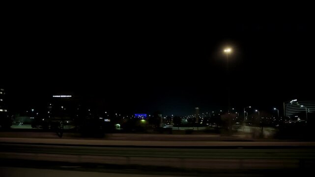 POV shot, driving on the highway during the night. Side view from the passenger side. 