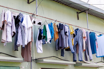 Obraz premium Assorted laundry hanging outdoors on clothesline against wall