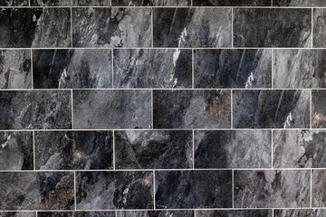 Dark slate tile wall with natural texture and varying grey tones