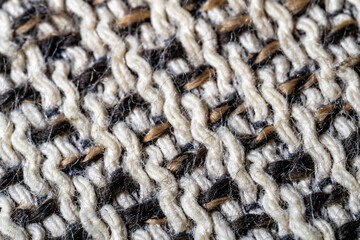 Detailed macro of textured wool fabric showing interwoven black and white yarns.