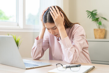 Stressed, exhausted asian young woman having migraine symptoms headache, bored sitting work long...