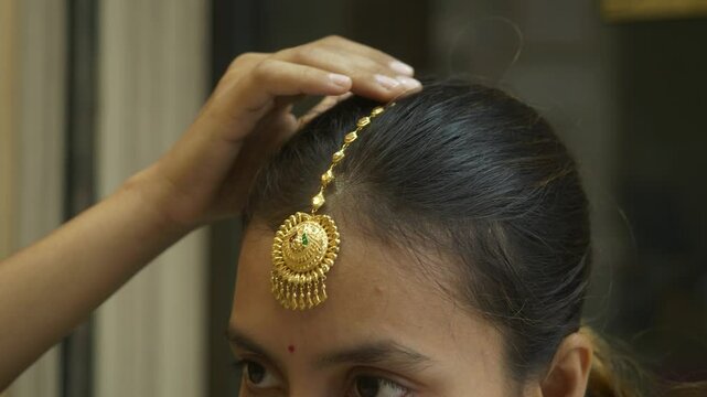 Young and beautiful south asian woman wearing head gold jewellery, Closeup