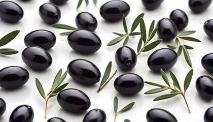 Black olives with fresh green olive branches scattered on a white surface.