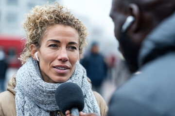 Close up, Journalist interviewing someone on a city street
