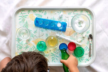 Child doing chemical and scientific experiment at home. Early development. Homeschool. Boy uses toy experiment set. Out-of-school learning, distance education. Little scientist Turkish toddler. 