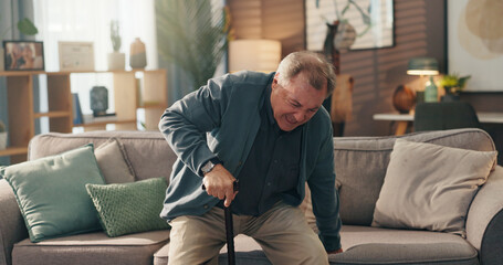 Senior man, walking stick and pain by sofa for injury, steps or balance for getting up in lounge....
