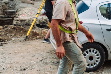 City infrastructure repair scene with open roads, red polypropylene pipes, construction workers, and excavation equipment. Urban utilities and roadwork maintenance in progress