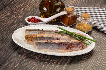 Salted marinated herring fillet with spices
