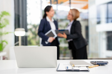 Two asian business persons working together. Businessman brainstorming, having a discussion with her colleague about work project at modern office. Business teamwork.