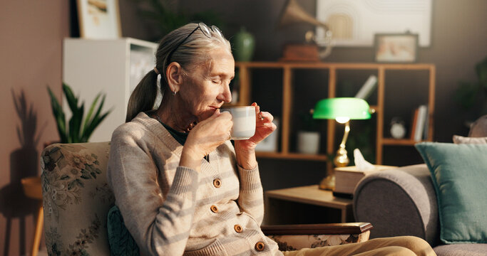 Senior woman, smell or morning with coffee for drink, beverage or aroma on chair at retirement home. Elderly, female person or relax with cup or mug of caffeine scent for warm roast at old age house