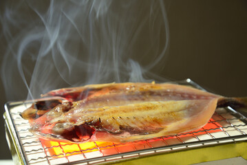 煙り立ち昇る七輪で鯵の開きを焼く