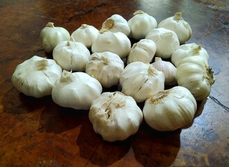 Pile of White Garlic Bulbs on Rustic Wooden Surface, Culinary Ingredient.