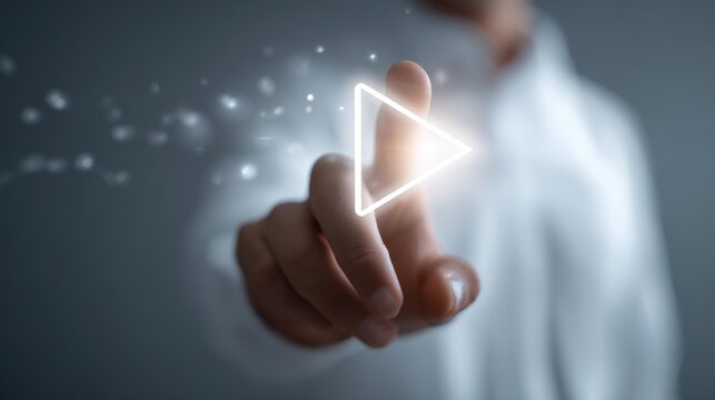 A hand pressing a glowing play button, symbolizing innovation and digital advancement.