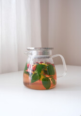 Invigorating Herbal Tea Infused with Fresh Mint and Seasonal Fruits Displayed in a Bright Setting