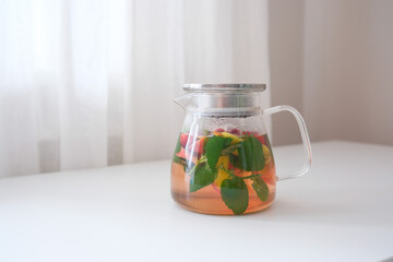 Invigorating Herbal Tea Infused with Fresh Mint and Seasonal Fruits Displayed in a Bright Setting