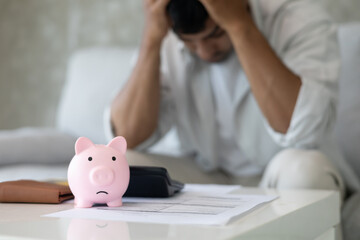 Stressed and headache man with large bills or invoices no money to pay to expenses and credit card...