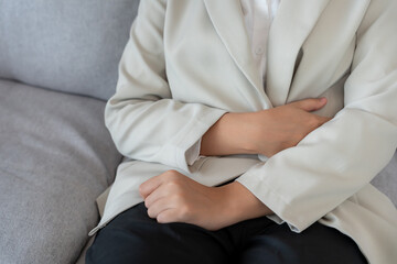 Business woman have stomach ache. Stomach ache due to eating irregularly, menstrual cramps,...