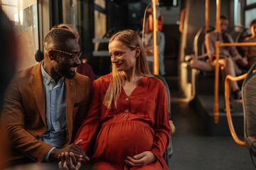Pregnant woman sitting with her husband on a bus