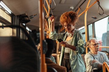 Fashionable young woman on the bus with a smartphone in her left hand © bernardbodo