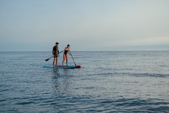 Two paddleboarders standing on paddleboarders