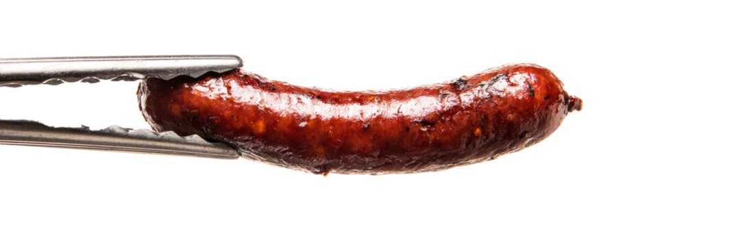 Sizzling sausage link held mid-air in tongs, glistening oil and browning, white background