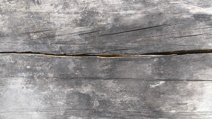 Rustic wood grain surface featuring horizontal weathered boards with natural cracks and texture....