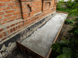 Spatula on the background of a concrete sidewalk near a house