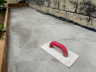 Spatula on the background of a concrete sidewalk near a house