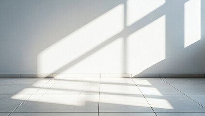 Obraz premium Sunlight casts geometric shadows on a white wall and tiled floor