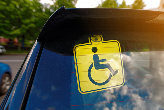 Disabled car sign on rear windscreen indicating accessibility needs for drivers with mobility impairments, safety and convenience on the road. Car with disabled sign on back windscreen