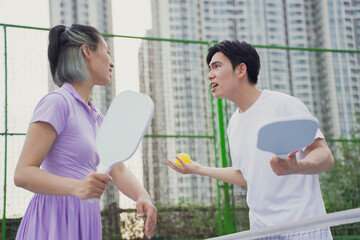 Playing pickleball in a vibrant urban setting with enthusiastic players engaged in friendly...