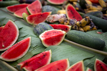 selective focus  Watermelon slices covered with banana leaves with various fruits. Elephant food at...