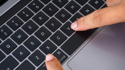 Full frame of finger pressing command and C letter button or cmd + C on a laptop keyboard, shortcut...