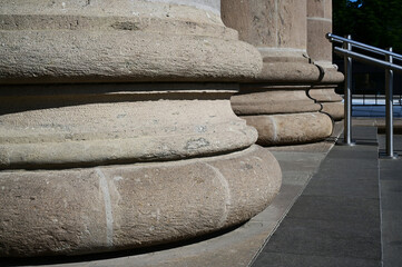 column base closeup of museum building. diminishing perspective view. classic architectural style.. classic forms and shapes. beige color porous stone texture. culture, travel ad tourism concept.