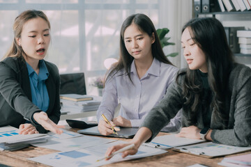 Three Asian business women making money from document graphs, analyzing ideas, teamwork, collaboration and planning with documents or business strategies in the office. business starting concept