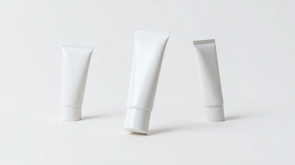 Three blank white cosmetic tubes for cream or lotion, clean minimalist product mockup isolated on pure white background for branding
