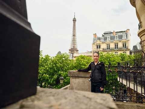 Young tourist admiring eiffel tower from parisian balcony