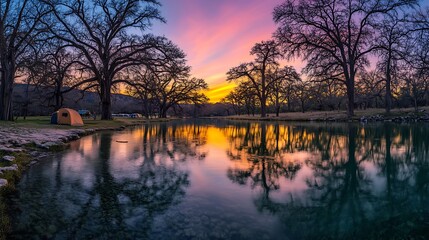 Sunset reflection on river with tent at the campsite